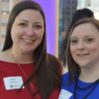 Two alumnae smile for a photo together at the Chicago Alumni Reception